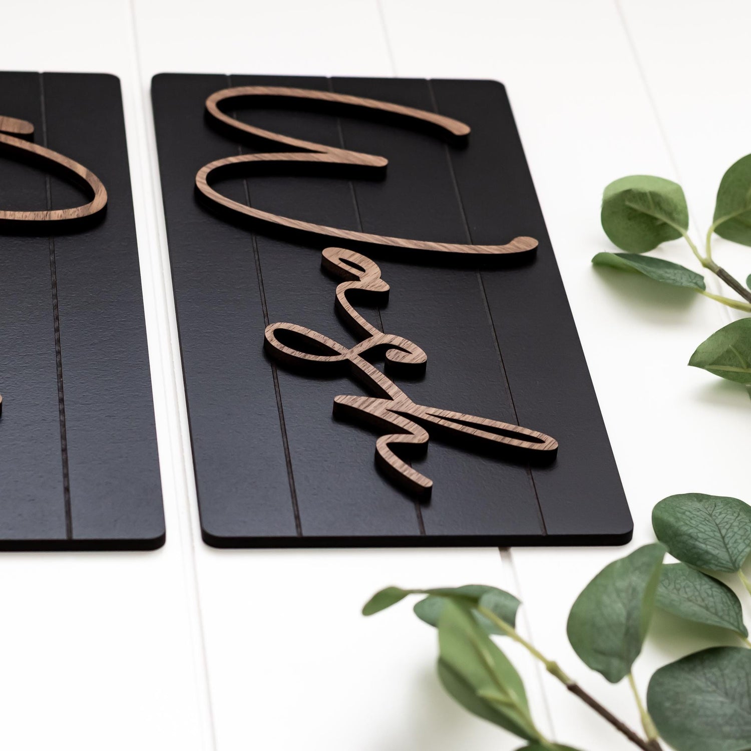 Detail view of dark wall sign panel with wood-tone cursive lettering, Wash and Dry style
