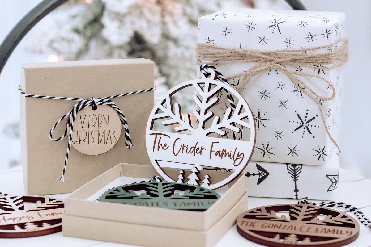 Engraved round family name ornament with hanging loop, in box with ribbon and wrapped keepsake
