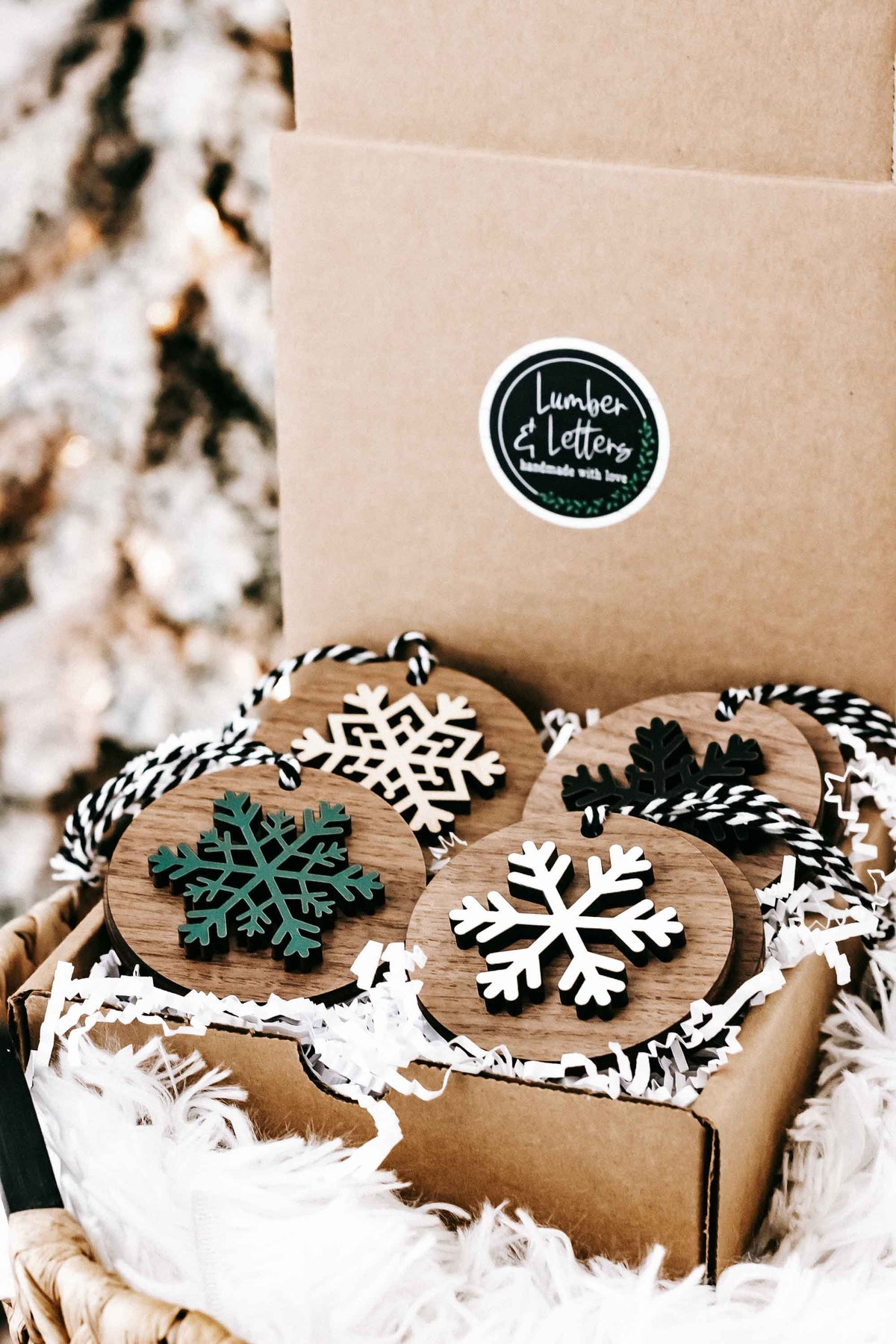 Pack of wooden snowflake ornaments with striped hangers, white, green, and dark snowflakes