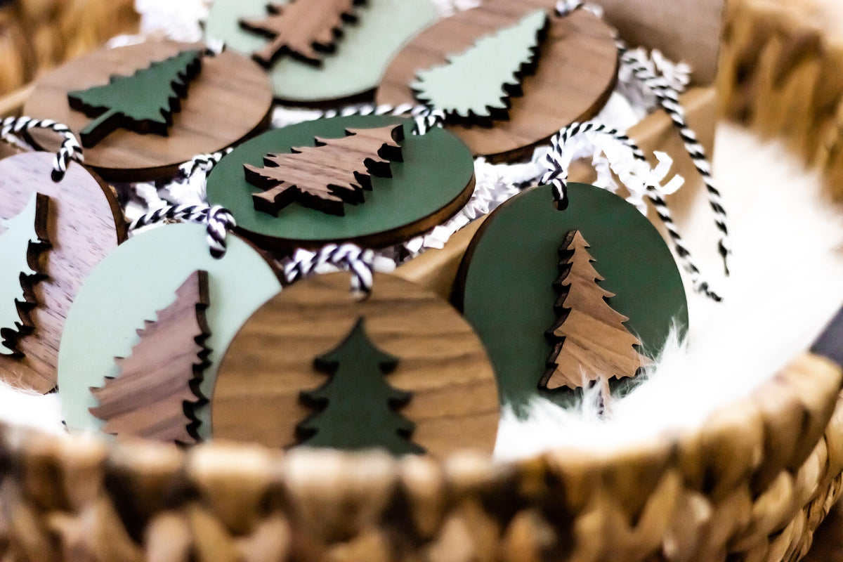 Close view of wooden Christmas tree ornaments with painted green details and striped cords