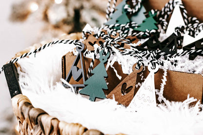 Assorted mini wooden Christmas ornaments with hanging loops, including tree and house shapes