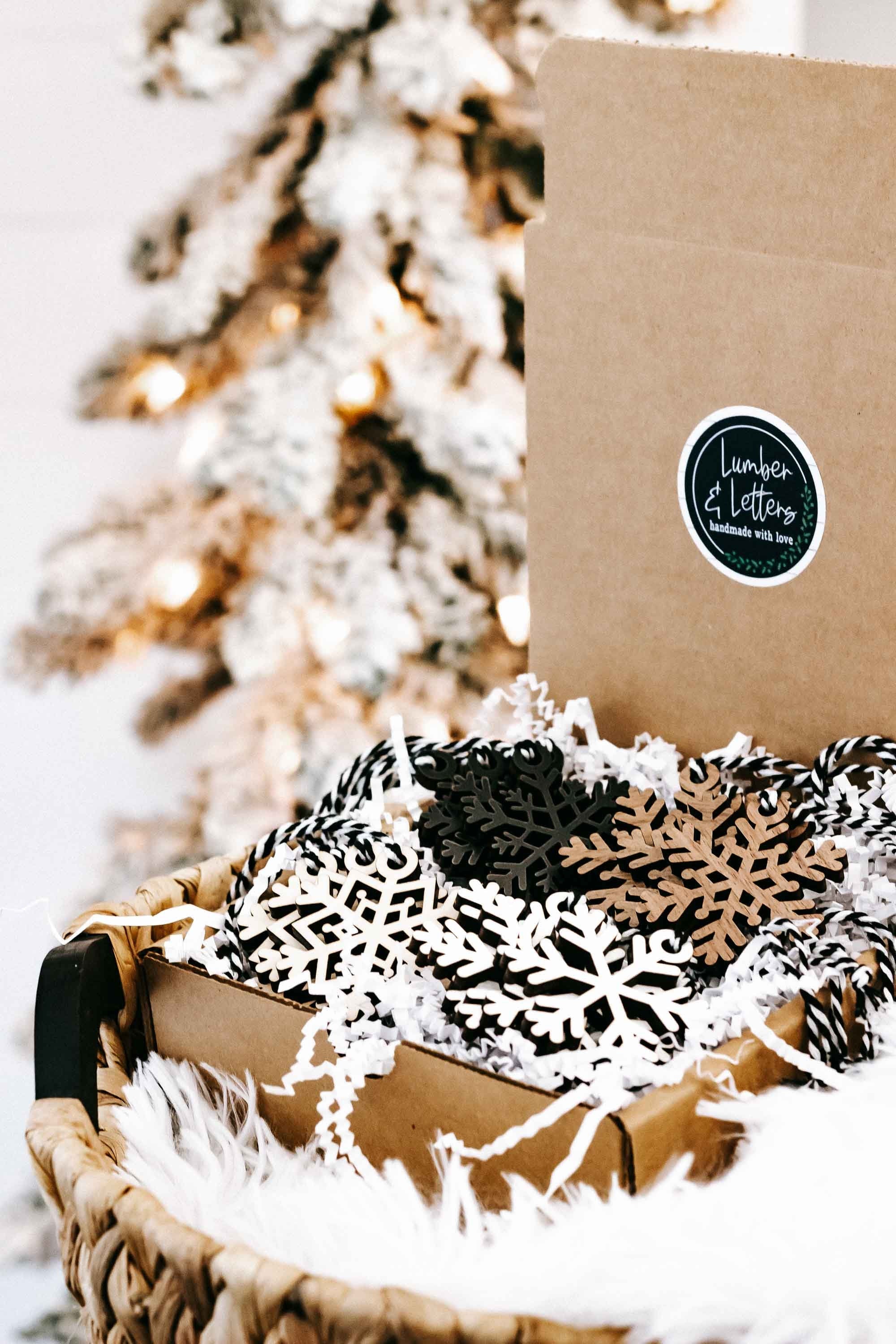 Snowflake wooden ornaments in a kraft gift box, black and beige with white cutout accents