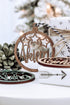 Brown wooden round name ornament with star cutouts and engraved name, tied gift