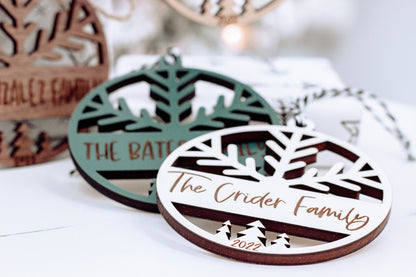 Engraved round Christmas ornaments with tree cutout and family name, dark wood and green