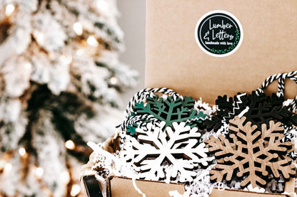 Wooden snowflake ornament set with dark, natural wood, and white accents, close-up