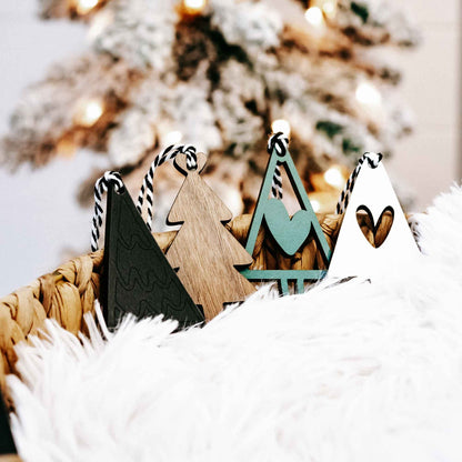 Assorted wooden Christmas tree ornaments with striped rope hangers in natural wood and dark green