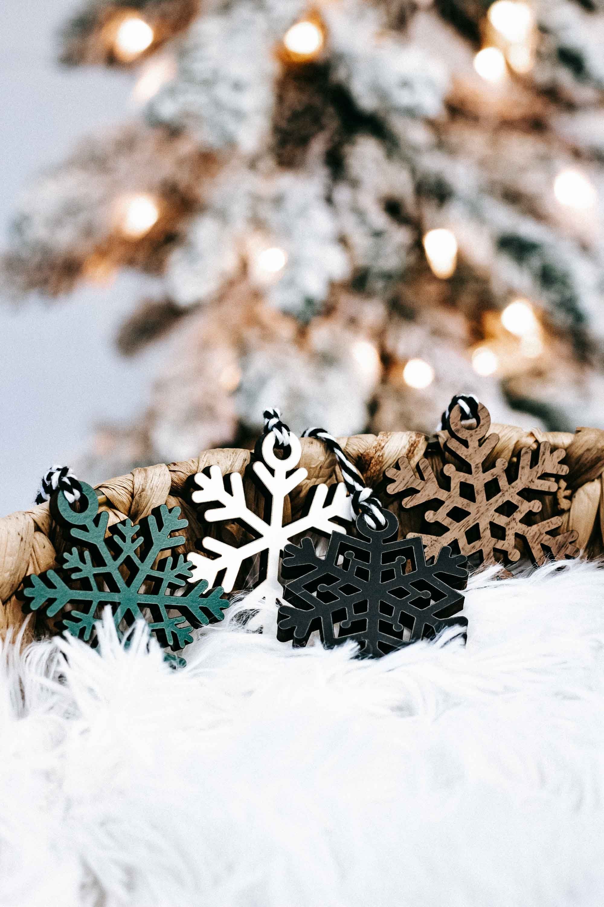 Snowflake Christmas ornaments on white faux fur, tied to twine with teal and tan accents