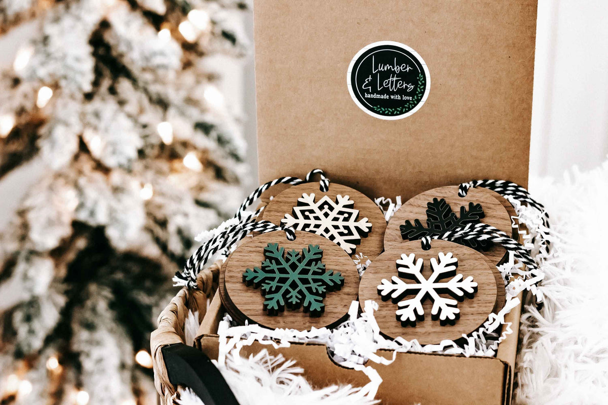 Wooden snowflake ornaments set with striped hangers, featuring white and dark snowflake faces