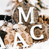 Round engraved pine cone ornament on black-and-white striped loop, year 2024