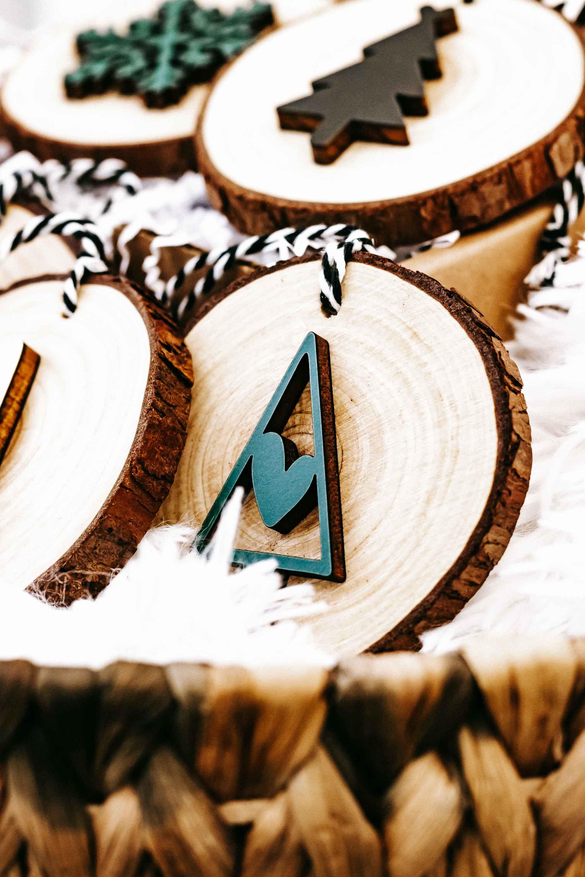 Wood slice ornament with teal tree cutout and string loop, part of set