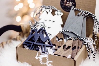 Close-up of wooden Christmas tree ornaments in navy and gray with striped hanging cords