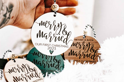 Set of round “Merry &amp; Married” Christmas ornaments held in hand, with year details