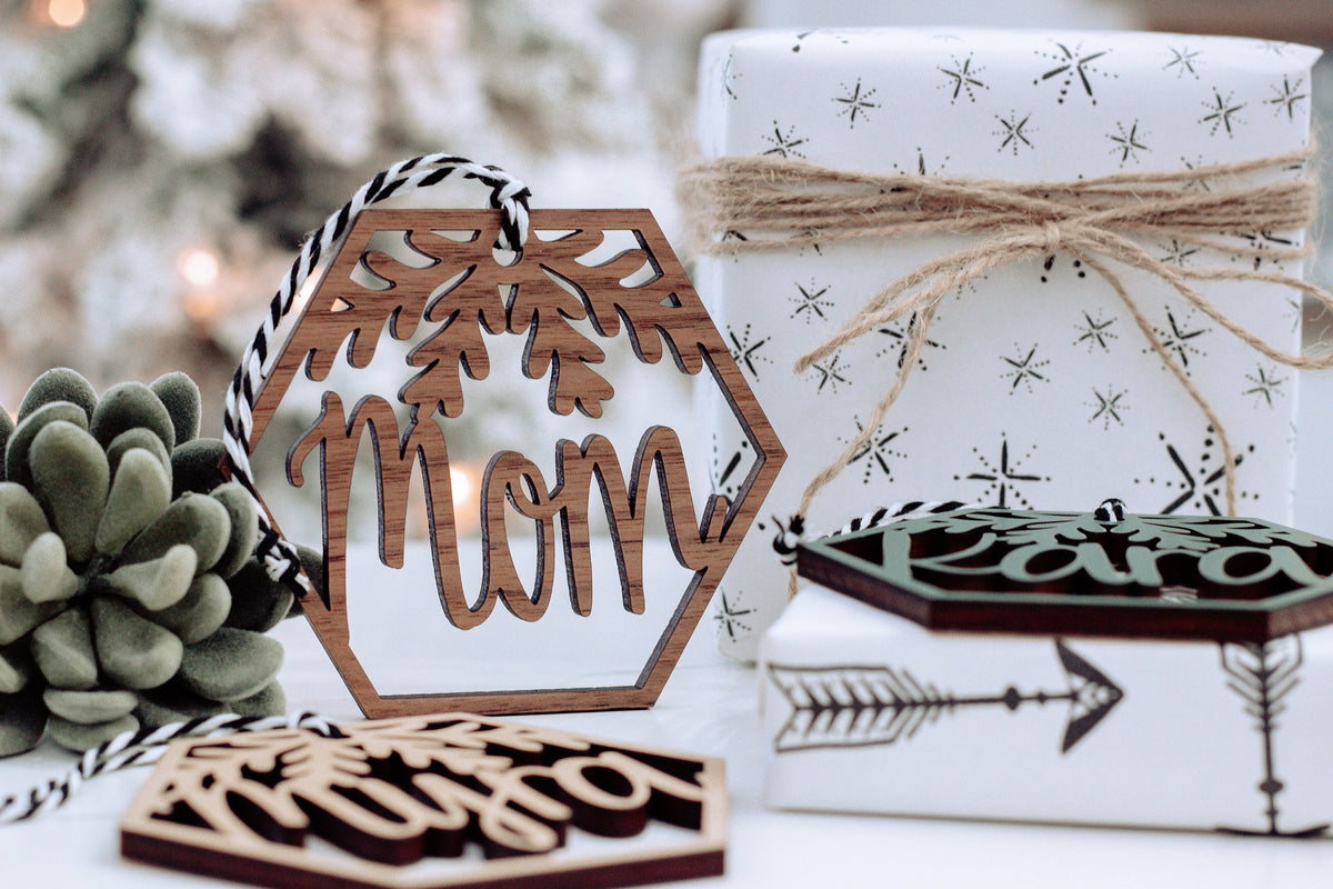 Wood hexagon name ornament with laser-cut tree design and gift box, brown and dark