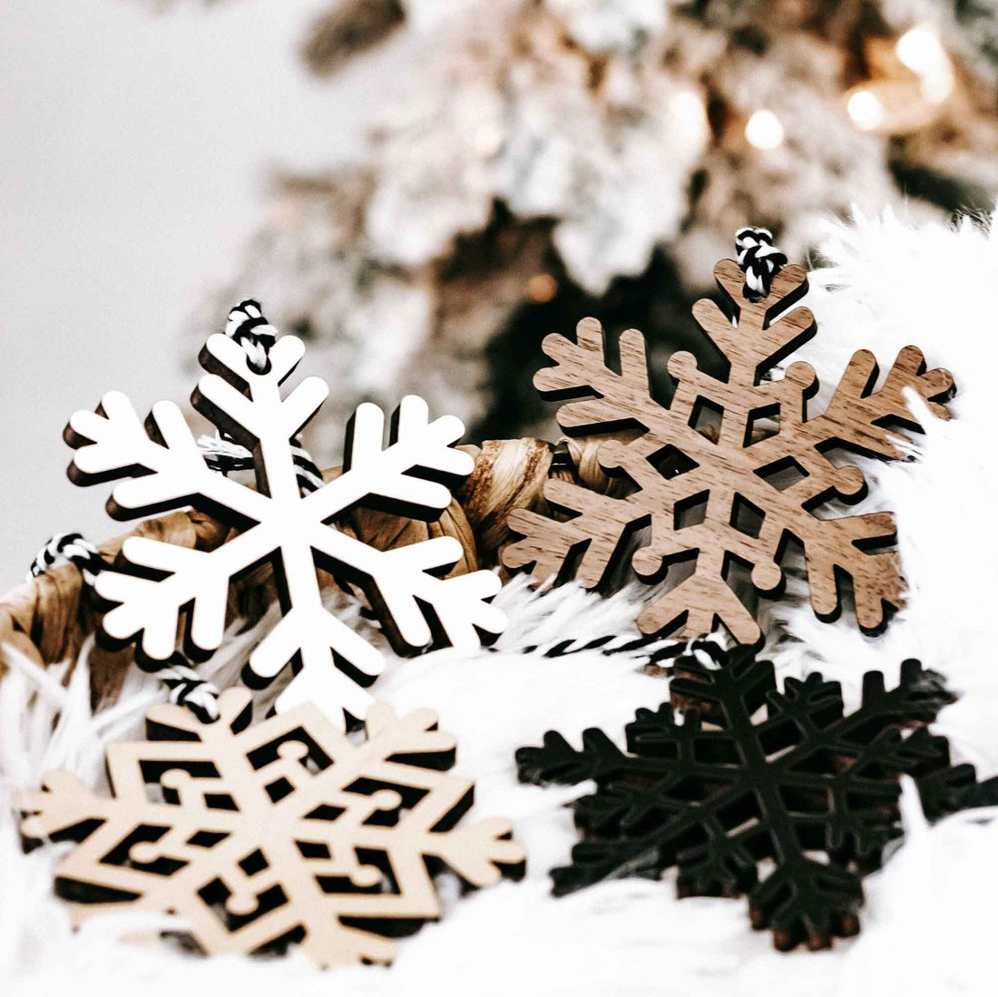 Wood snowflake ornament set: white, dark, and tan cutout snowflakes with hanging loops