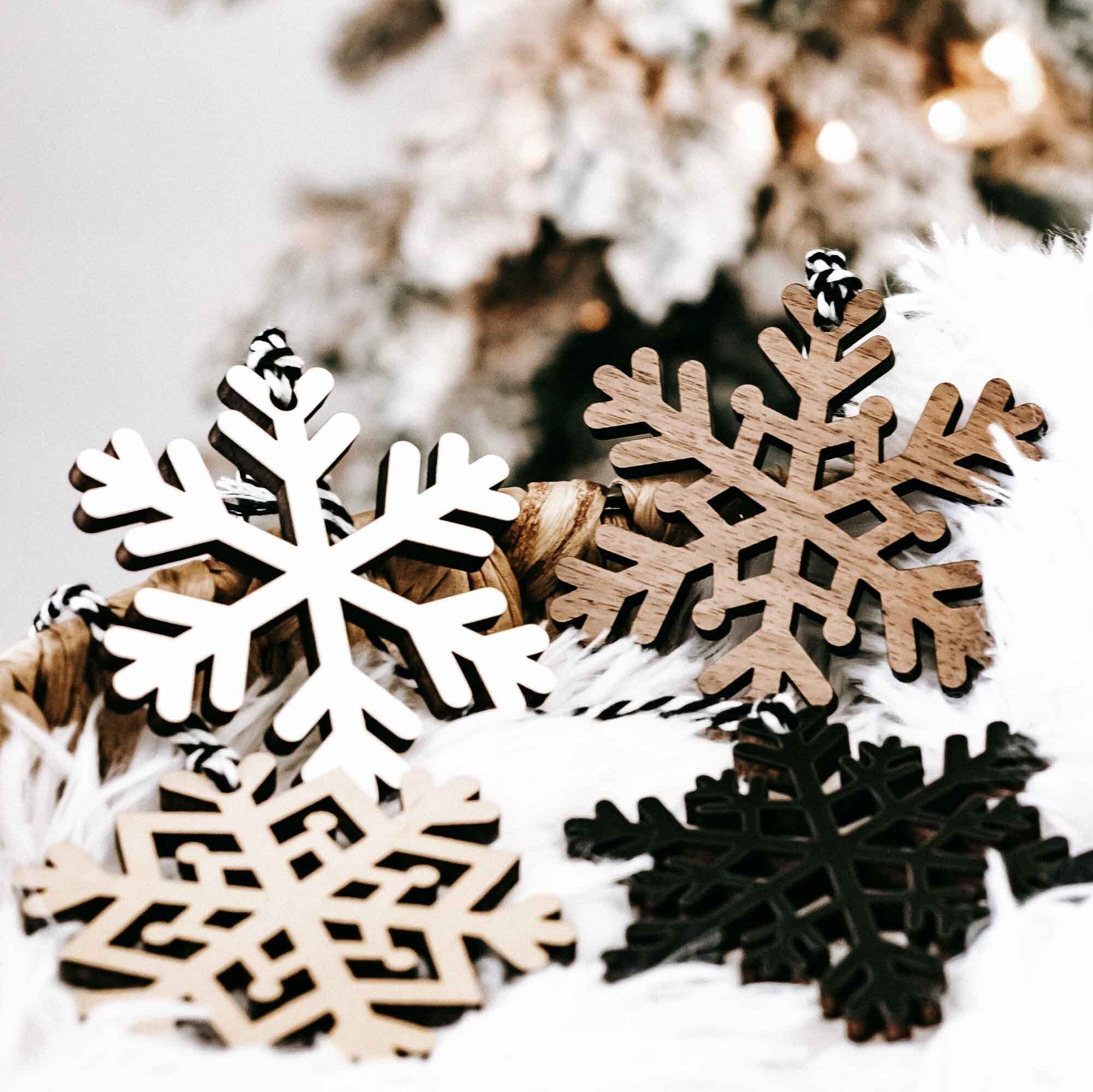 Wood snowflake ornament set: white, dark, and tan cutout snowflakes with hanging loops