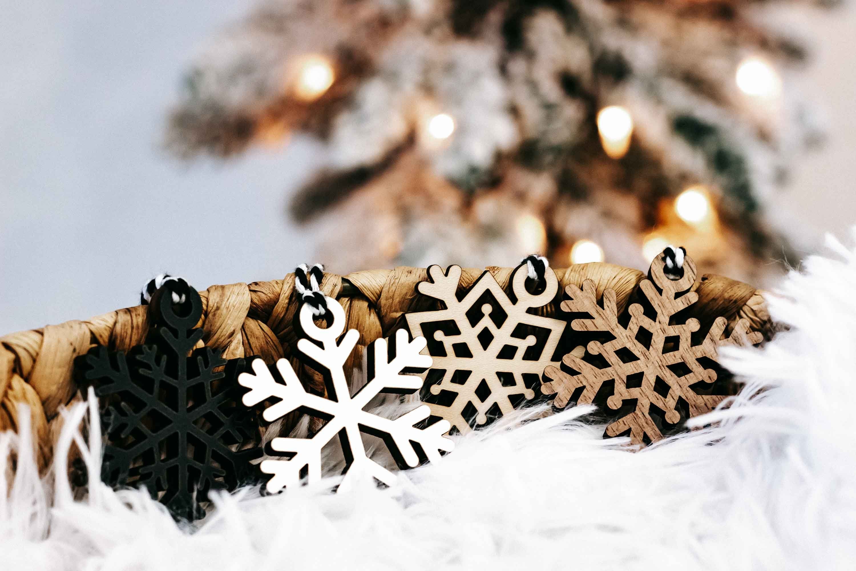 Snowflake wooden ornaments on white faux fur, black and white cutout snowflake designs