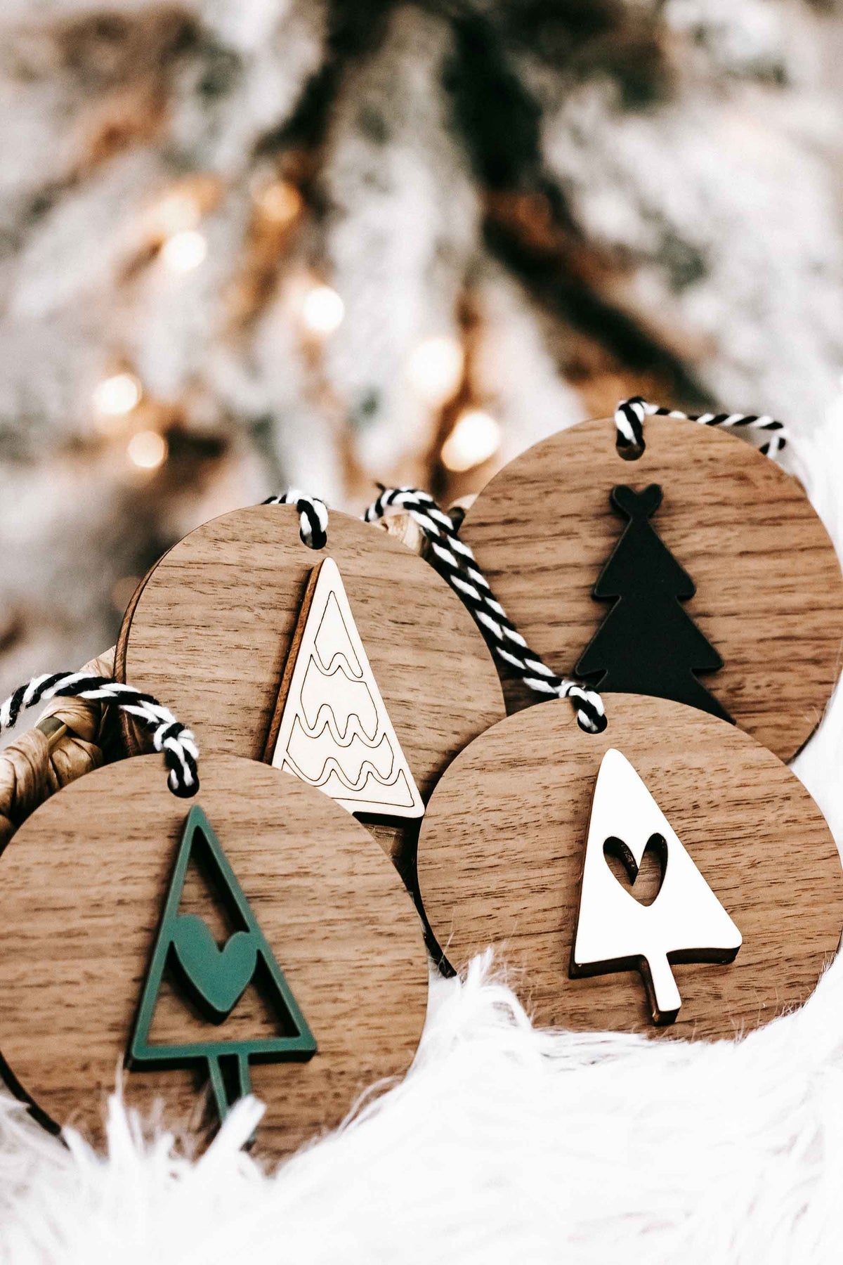 Close-up of wooden Christmas ornaments with striped strings and tree, star, and snowflake cutouts