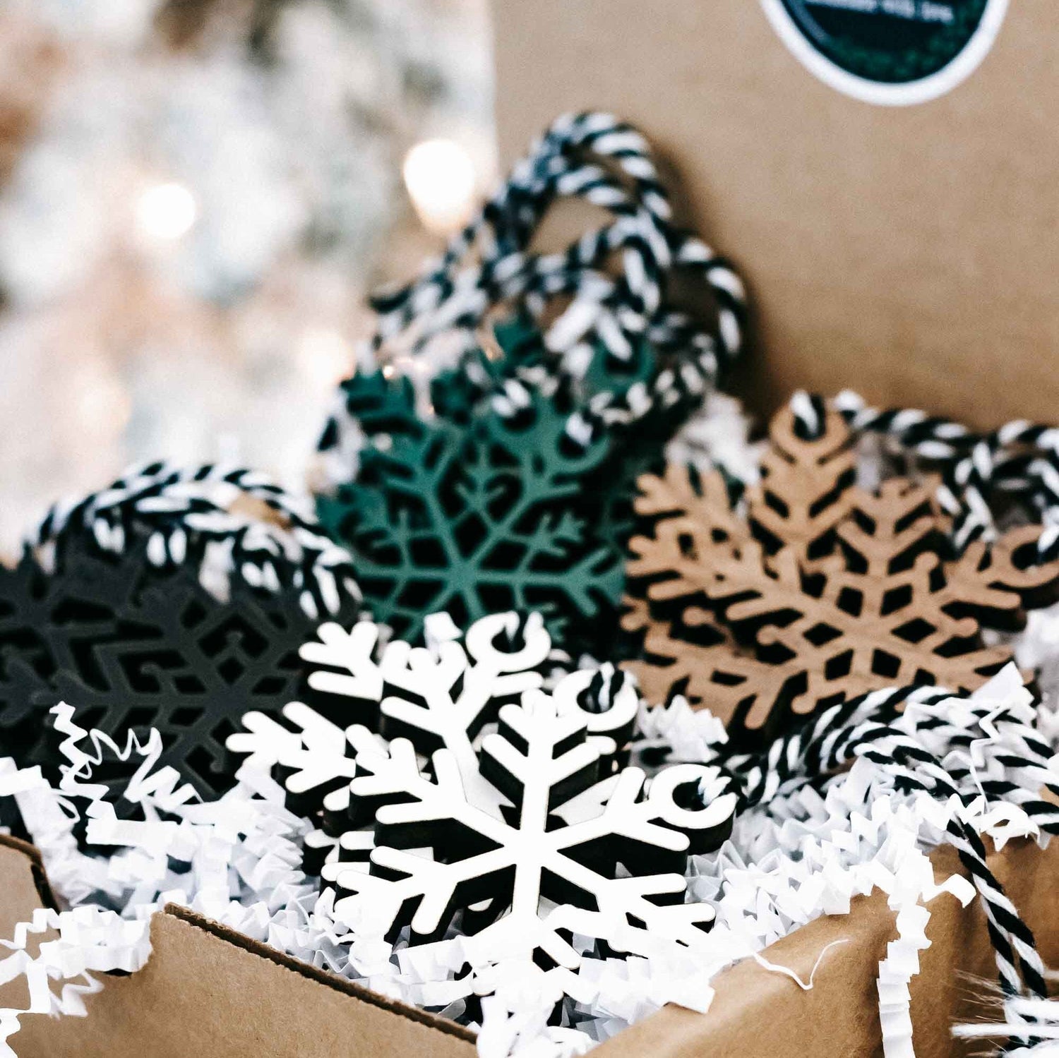 Set of snowflake Christmas ornaments in black, white, teal, and tan on white filler