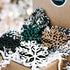 Set of snowflake Christmas ornaments in black, white, teal, and tan on white filler