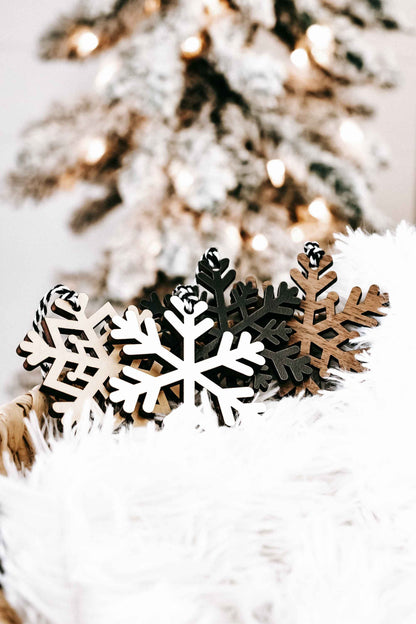 Wood snowflake ornaments set: white, dark, and tan snowflake cutouts with small top loops