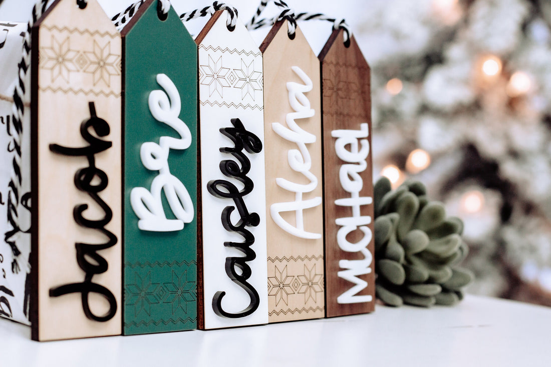 Wooden stocking tags with Scandinavian patterns in white, teal, and brown, strung on twine.