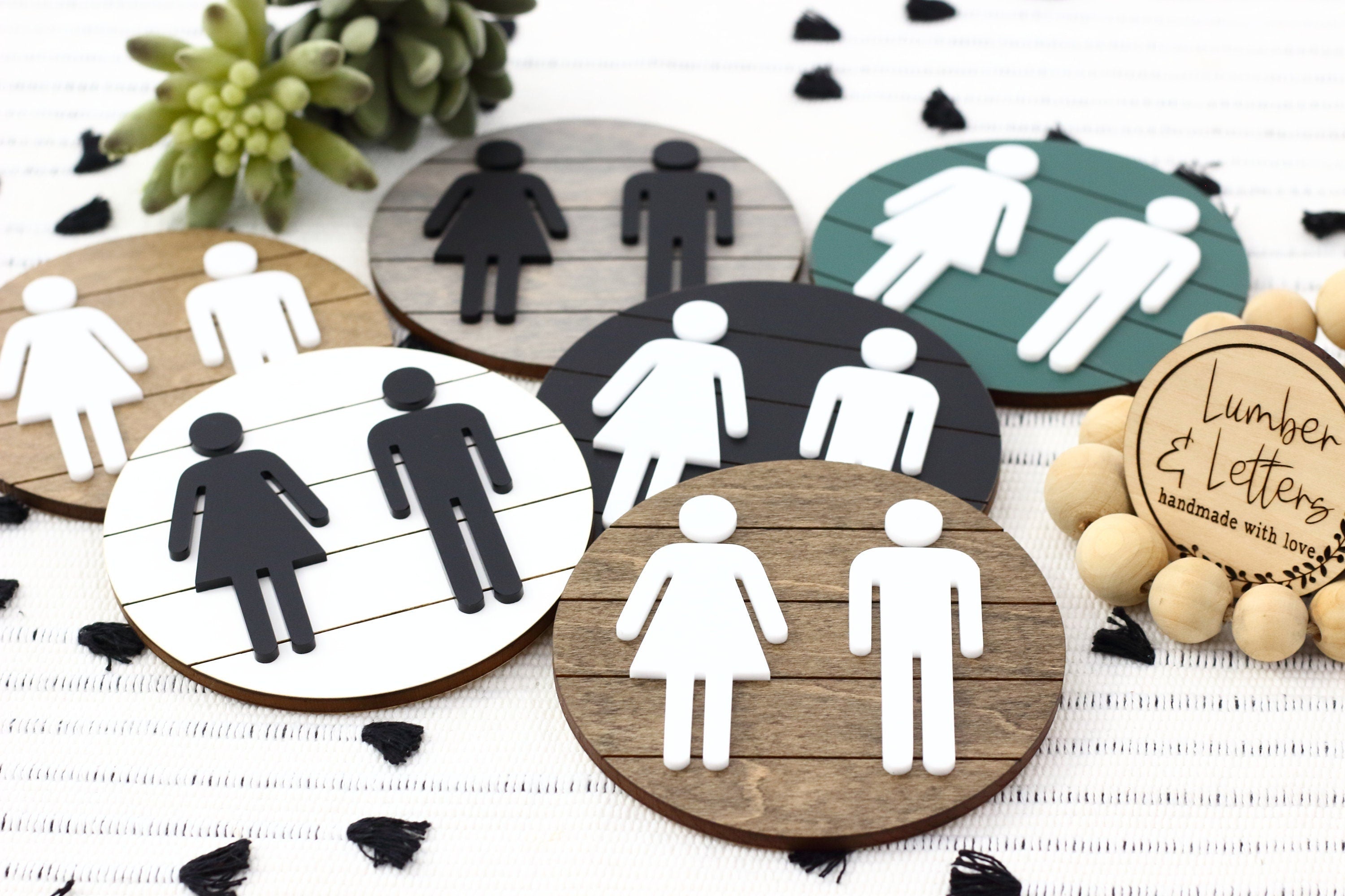 Assorted round 3D restroom accessibility signs with male, female, and wheelchair icons