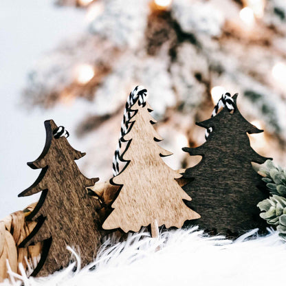 Rustic wooden Christmas tree ornaments with faux-frost edges and striped hanging loops.