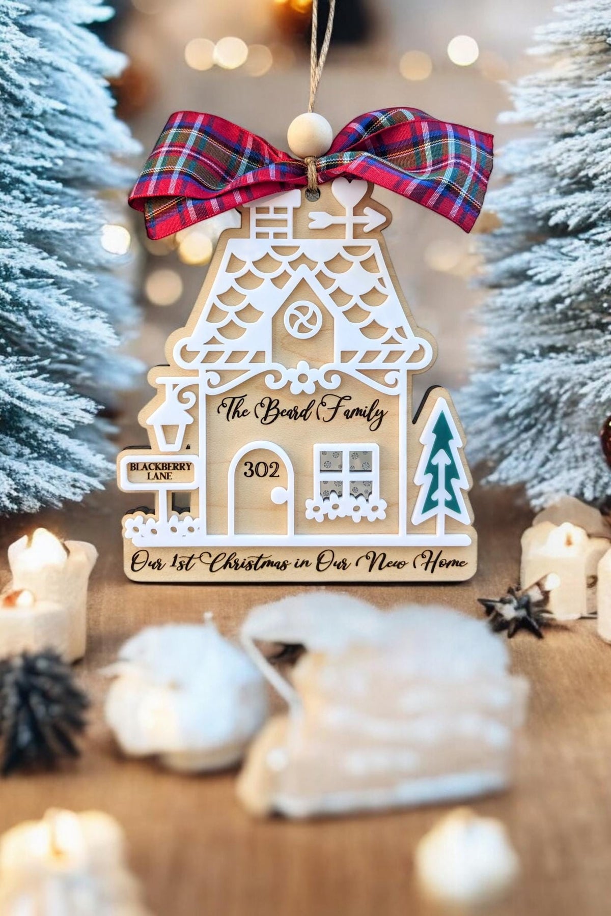 Wood gingerbread house ornament with red plaid bow, “302,” “Bond Family,” and teal tree