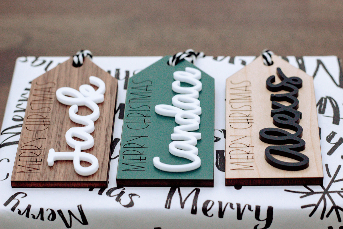 Set of wood gift tags with raised Merry Christmas lettering and black-and-white rope ties