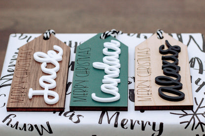 Set of wood gift tags with raised Merry Christmas lettering and black-and-white rope ties