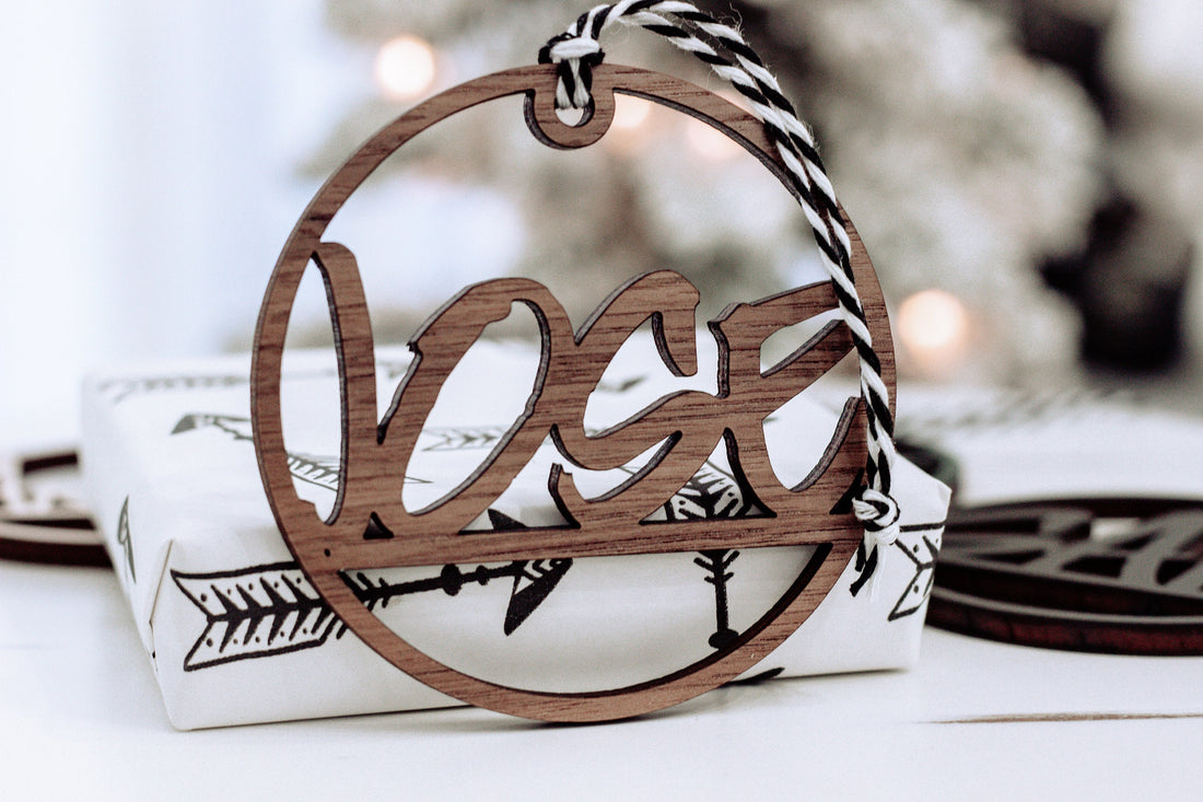 Brown wooden laser-cut custom name ornament with hanging ribbon, circular frame
