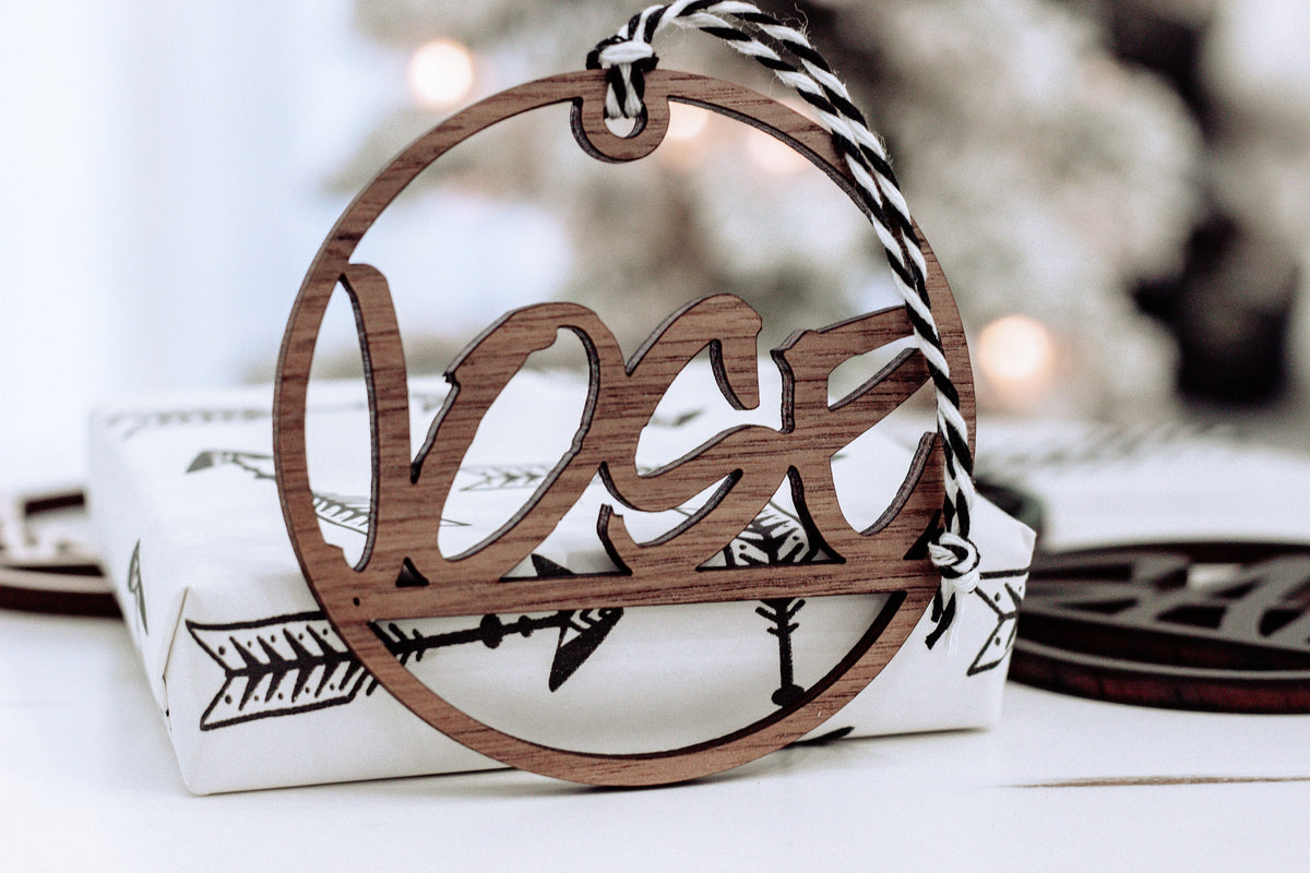 Brown wooden laser-cut custom name ornament with hanging ribbon, circular frame