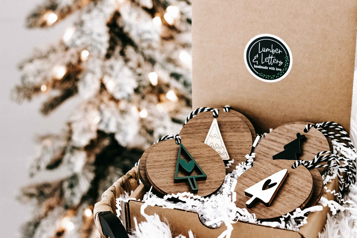 Wooden ornament set in kraft box with tree, star and cross shapes on striped string hangers