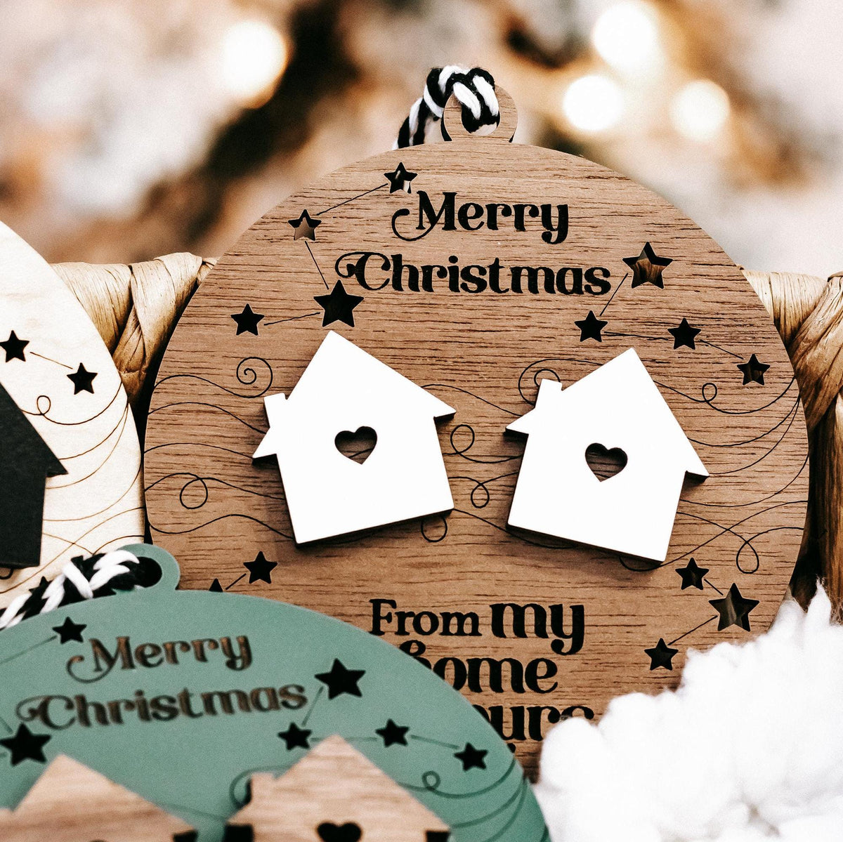 Round wooden “Merry Christmas” ornament with two white house icons and star accents
