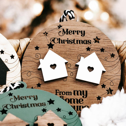 Round wooden “Merry Christmas” ornament with two white house icons and star accents