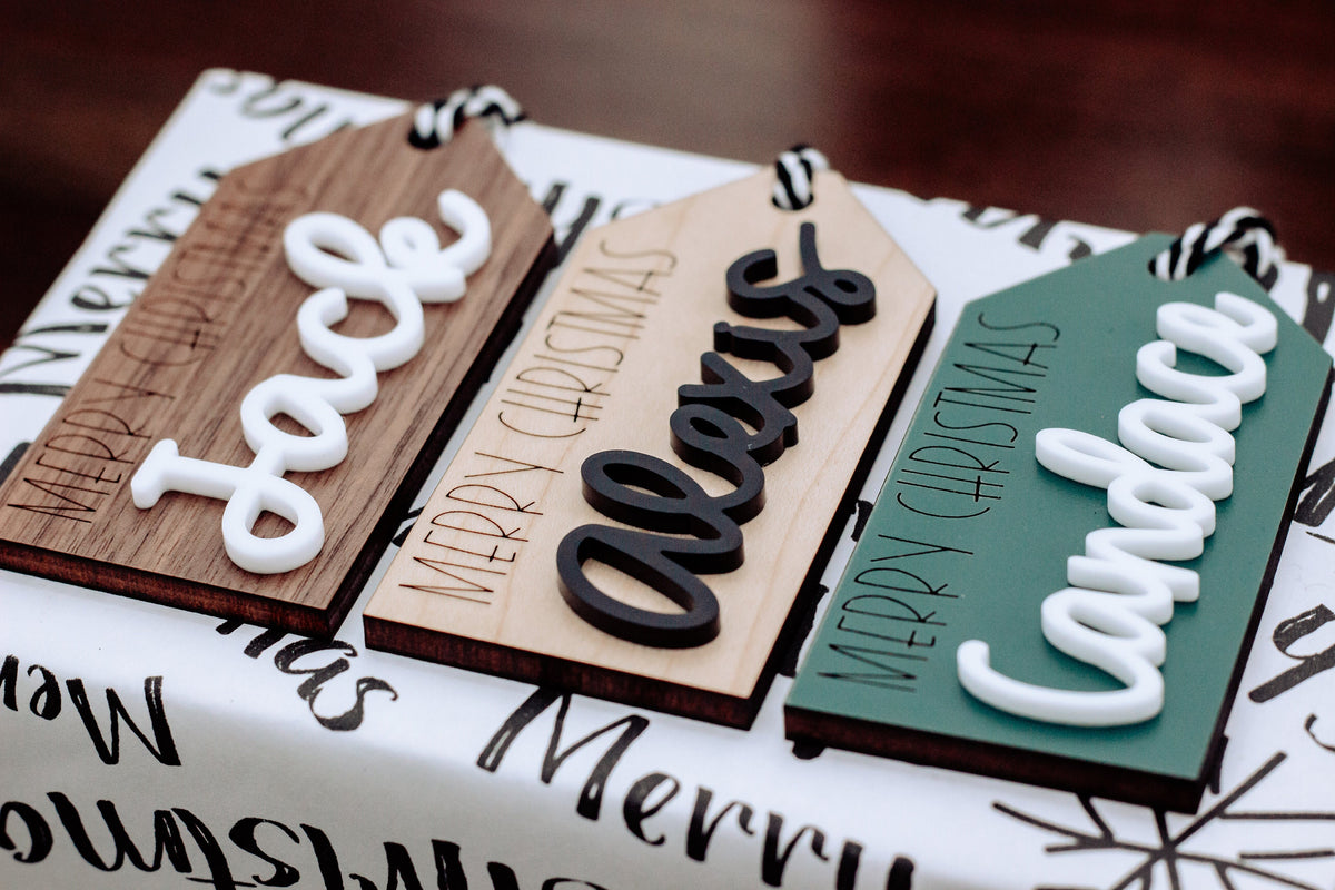 Wood gift tags with raised Merry Christmas lettering in light, black, and green tones