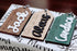 Wood gift tags with raised Merry Christmas lettering in light, black, and green tones