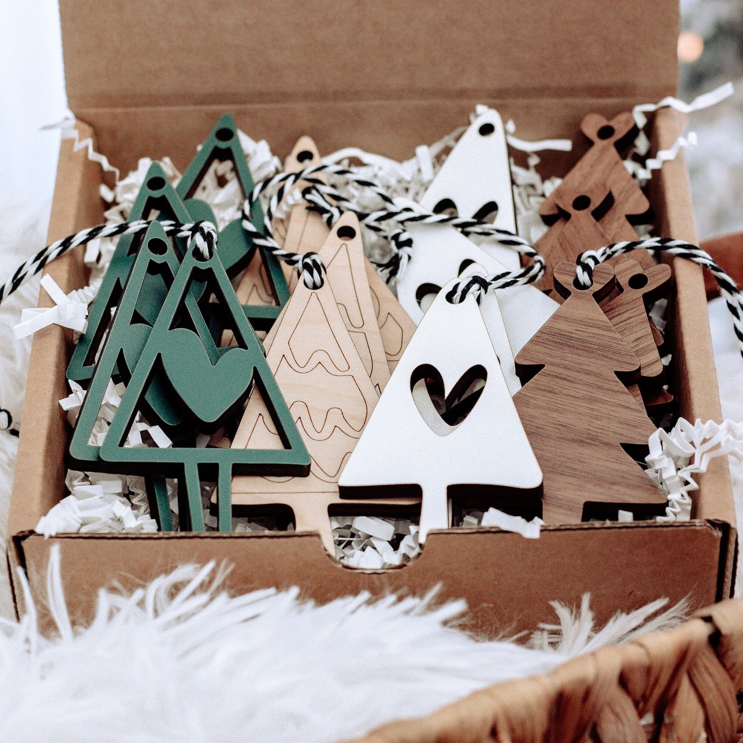 Set of wooden Christmas ornaments with strings: green tree, white tree, and heart cutouts