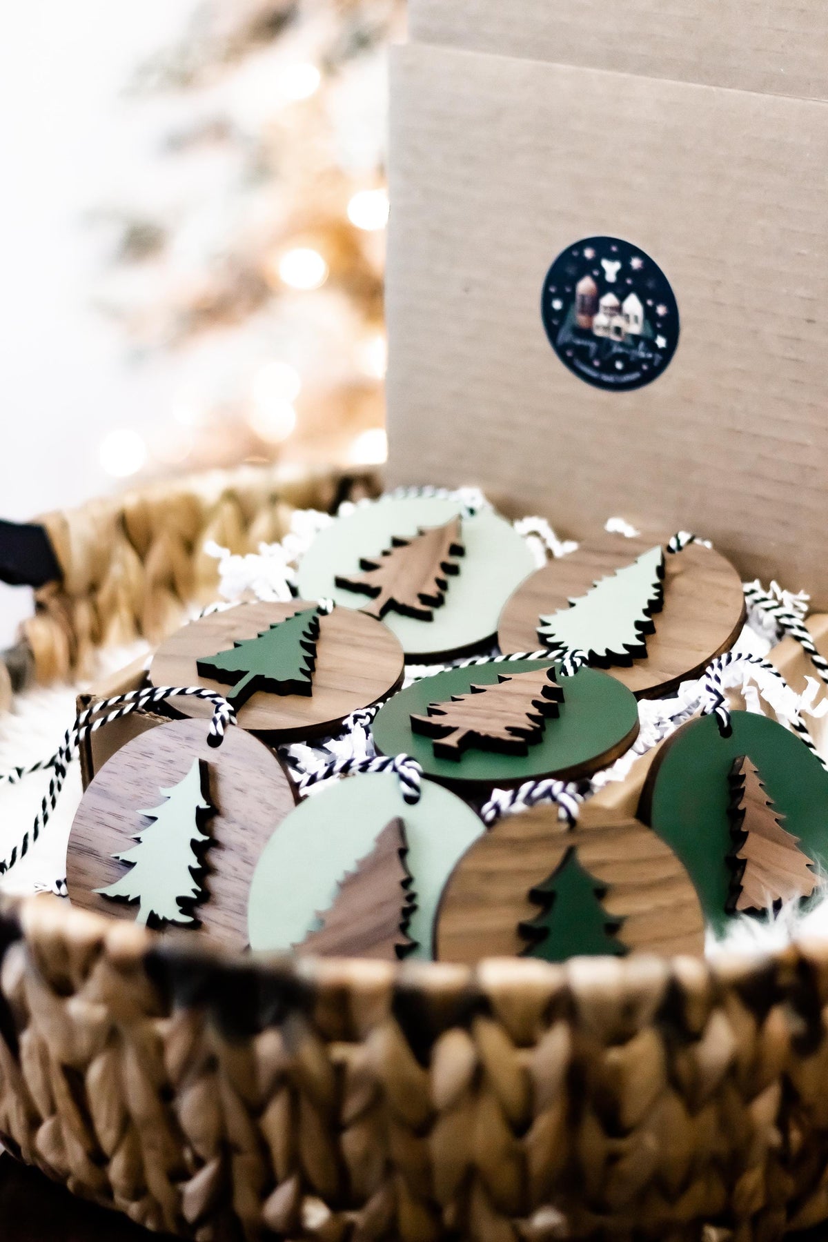 Set of wooden Christmas tree ornaments arranged in a box with striped string hangers