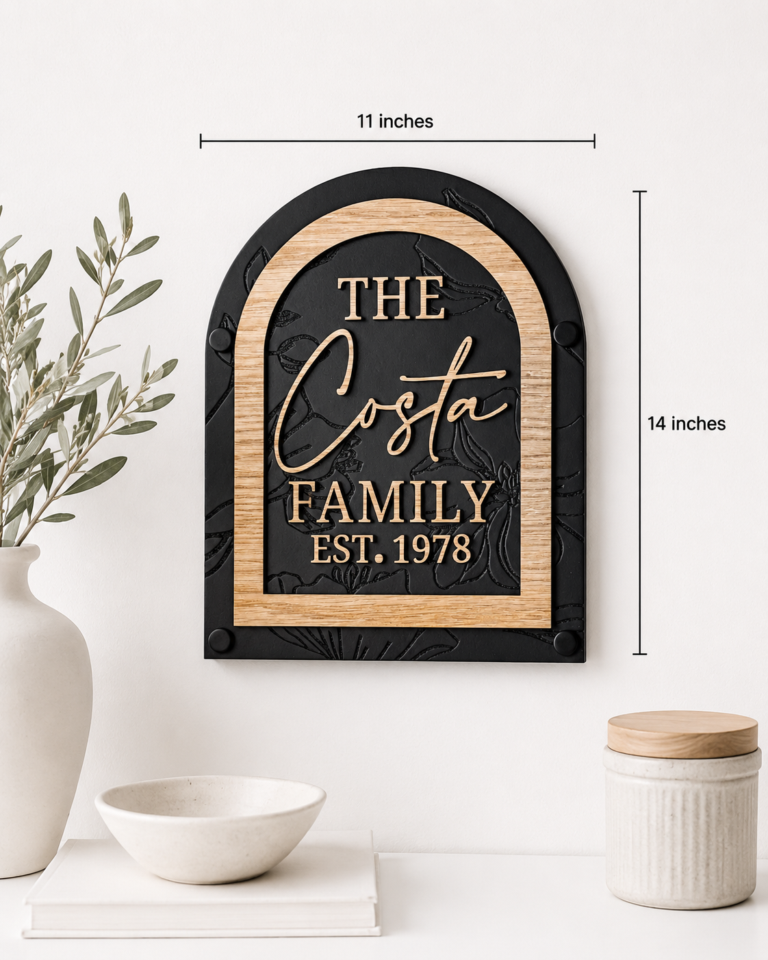 Black framed arch family name sign with gold script “Costa” and “FAMILY EST. 1978”.