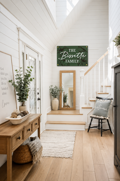 Dark green rectangular family name sign with bird-and-floral engraving: THE Bissette
