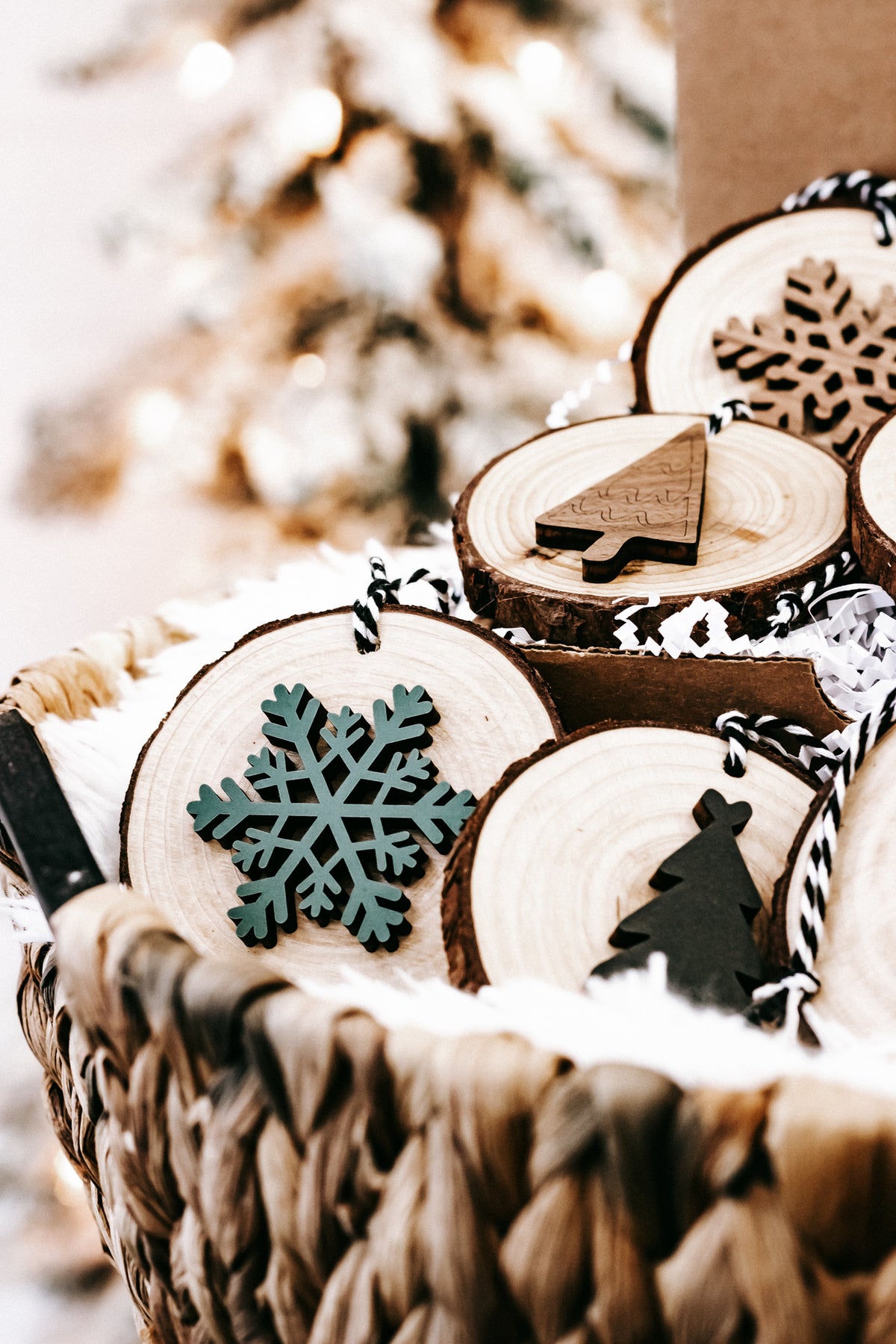 Rustic wood slice ornaments with snowflake and tree cutouts, tied on black-and-white strings