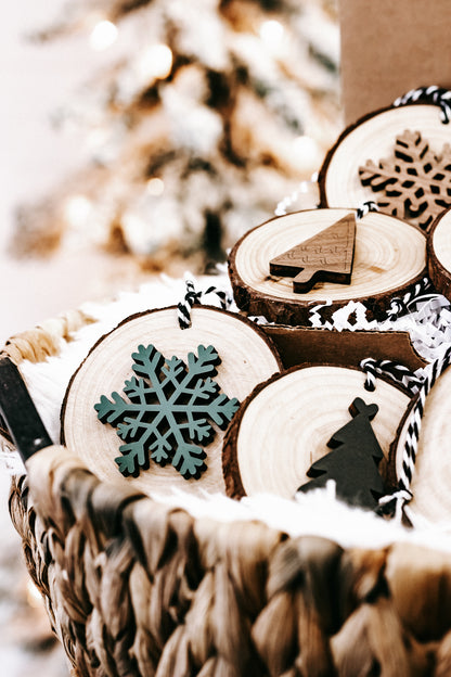 Rustic wood slice ornaments with snowflake and tree cutouts, tied on black-and-white strings