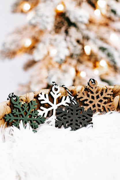 Set of mixed-color snowflake ornaments with braided string loops in a straw basket