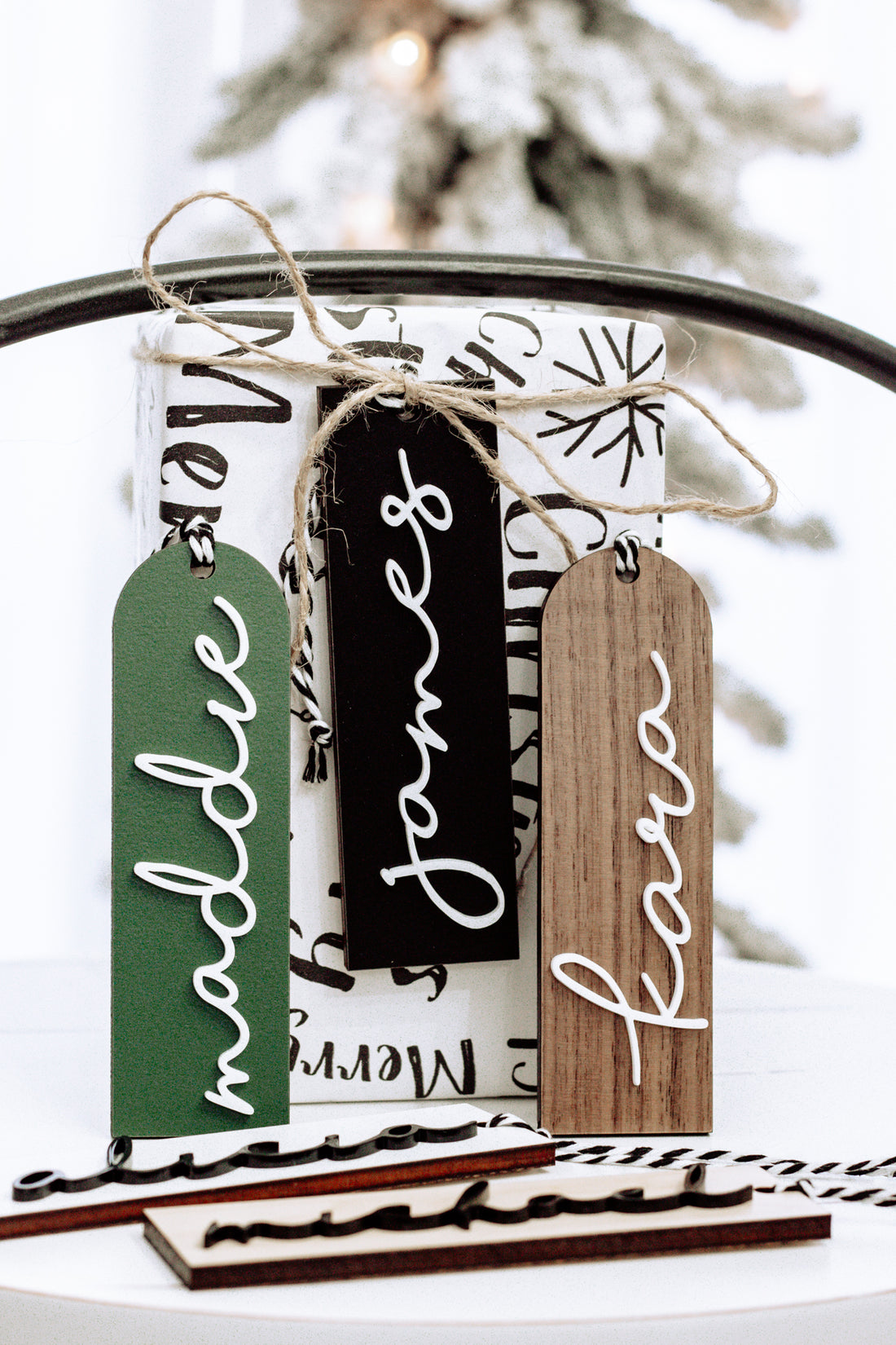 Hanging modern stocking tags in green, black, and brown with white script