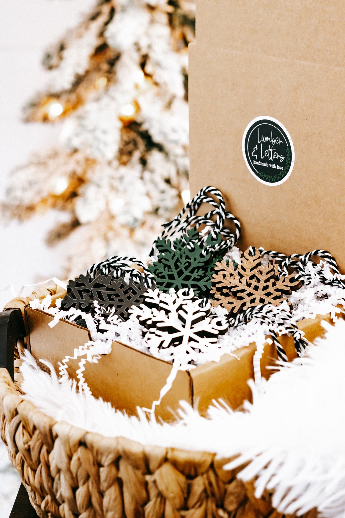Set of snowflake Christmas tree ornaments in black, white, green, and tan with string loops
