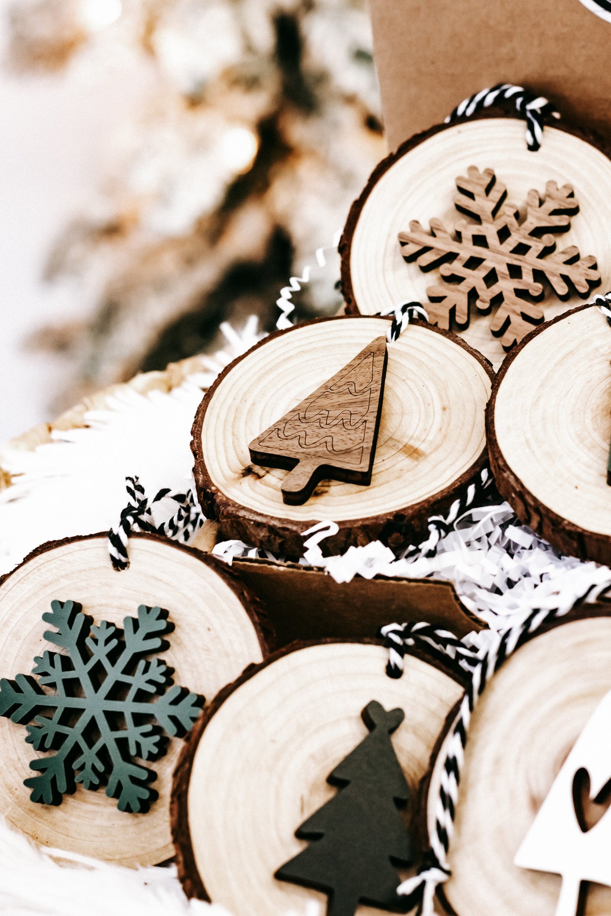 Rustic wood slice ornament cluster with snowflake and tree silhouettes, on hanging strings