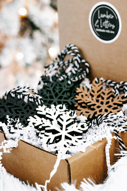 Close-up of mixed-color snowflake Christmas tree ornaments with black-and-white string loops
