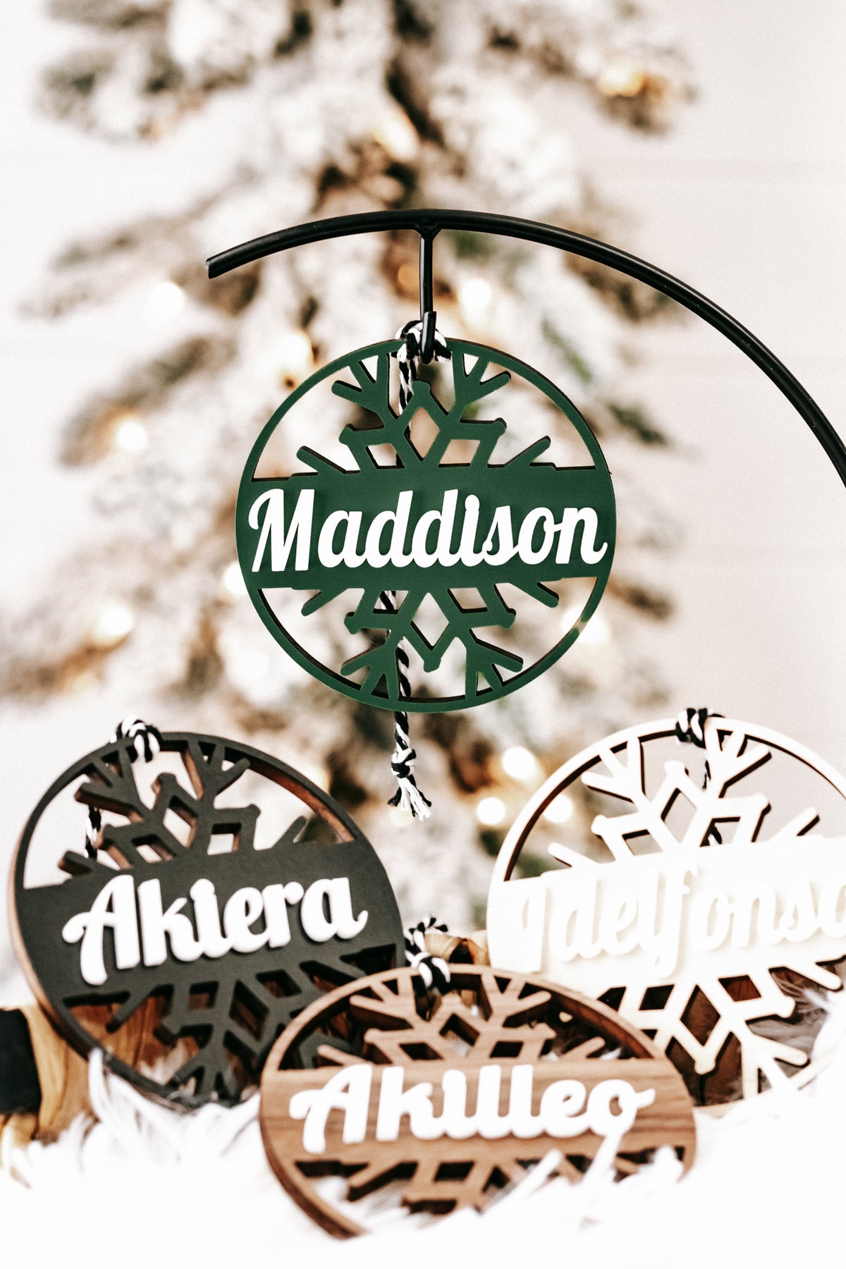 Personalized snowflake ornaments set with engraved names and dark metal hanger, gift-ready