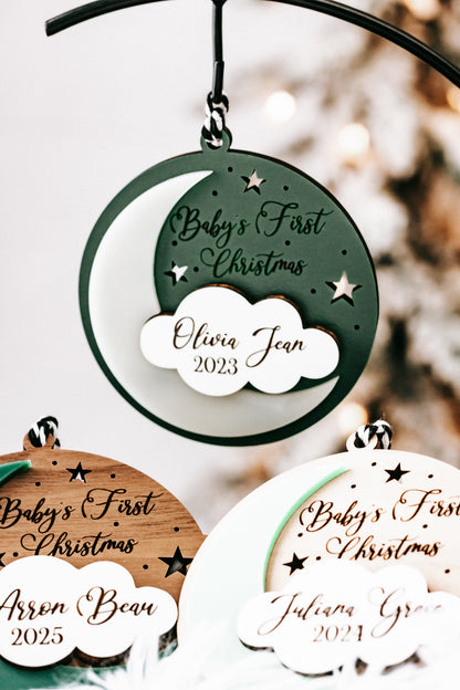 Green hanging round ornament with white cloud tag: Olivia Jean, 2023; other ornaments below.